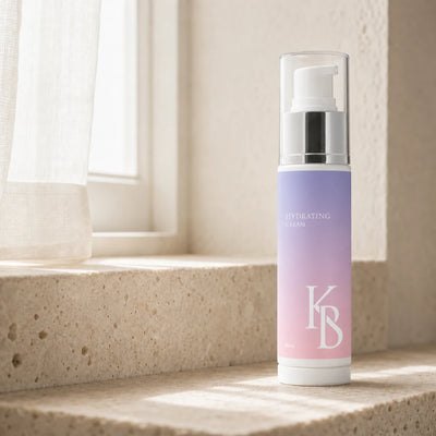 Kaloneo Beauty Hydrating Cream 60ml standing on a travertine window ledge in morning light, a sheer curtain filtering the sun behind it