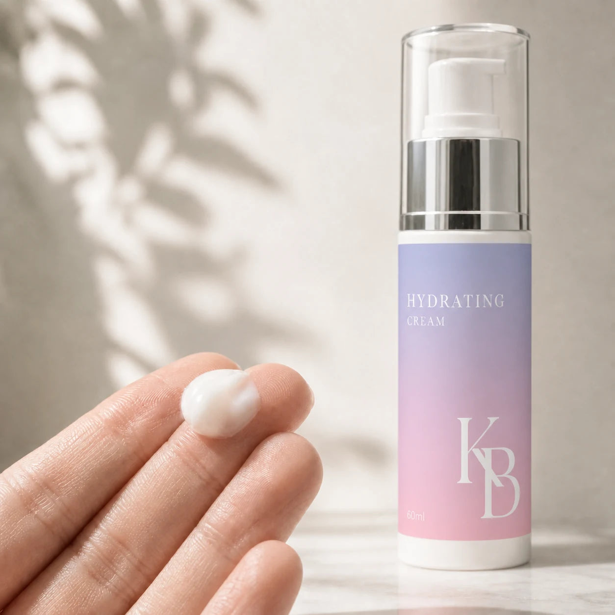 A pearl of Kaloneo Beauty Hydrating Cream on fingertips beside the 60ml bottle, showing the lightweight non-greasy texture