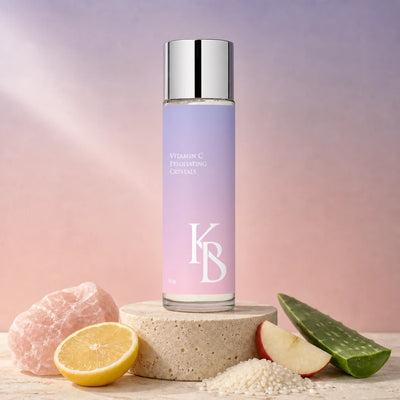 Kaloneo Beauty Vitamin C Exfoliating Crystals 50g on a stone plinth with rose quartz, lemon, rice, apple and aloe vera, the ingredients used in the formula