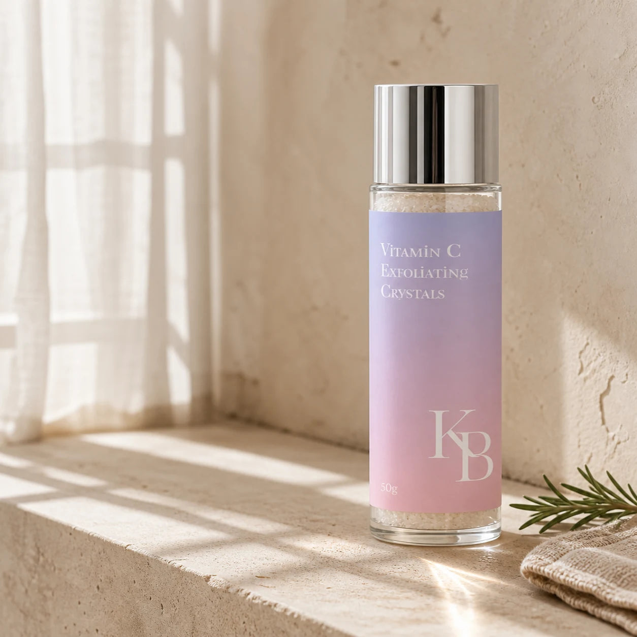 Kaloneo Beauty Vitamin C Exfoliating Crystals 50g in a clear glass bottle on a travertine bathroom ledge in warm morning light