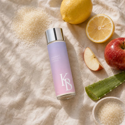 Kaloneo Beauty Vitamin C Exfoliating Crystals on linen with lemon, red apple and aloe vera, the ingredients used in the formula